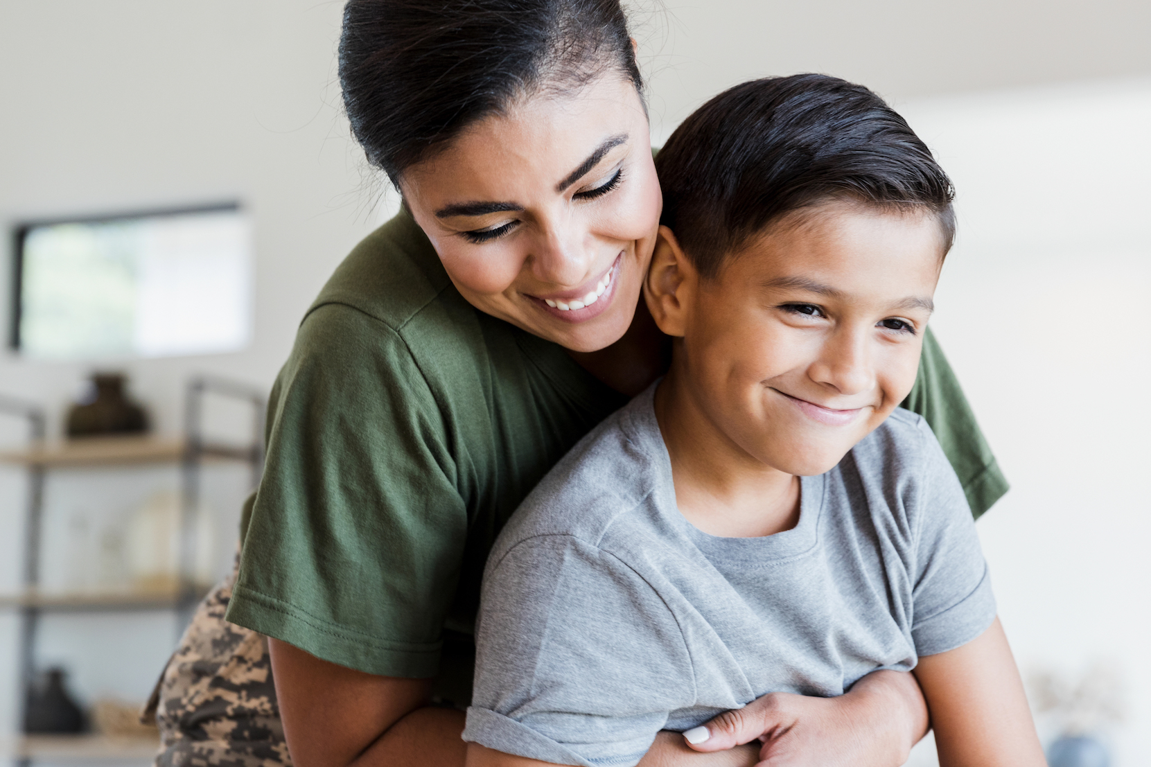 Child life insurance blog header Mom gives son a hug in the living room
