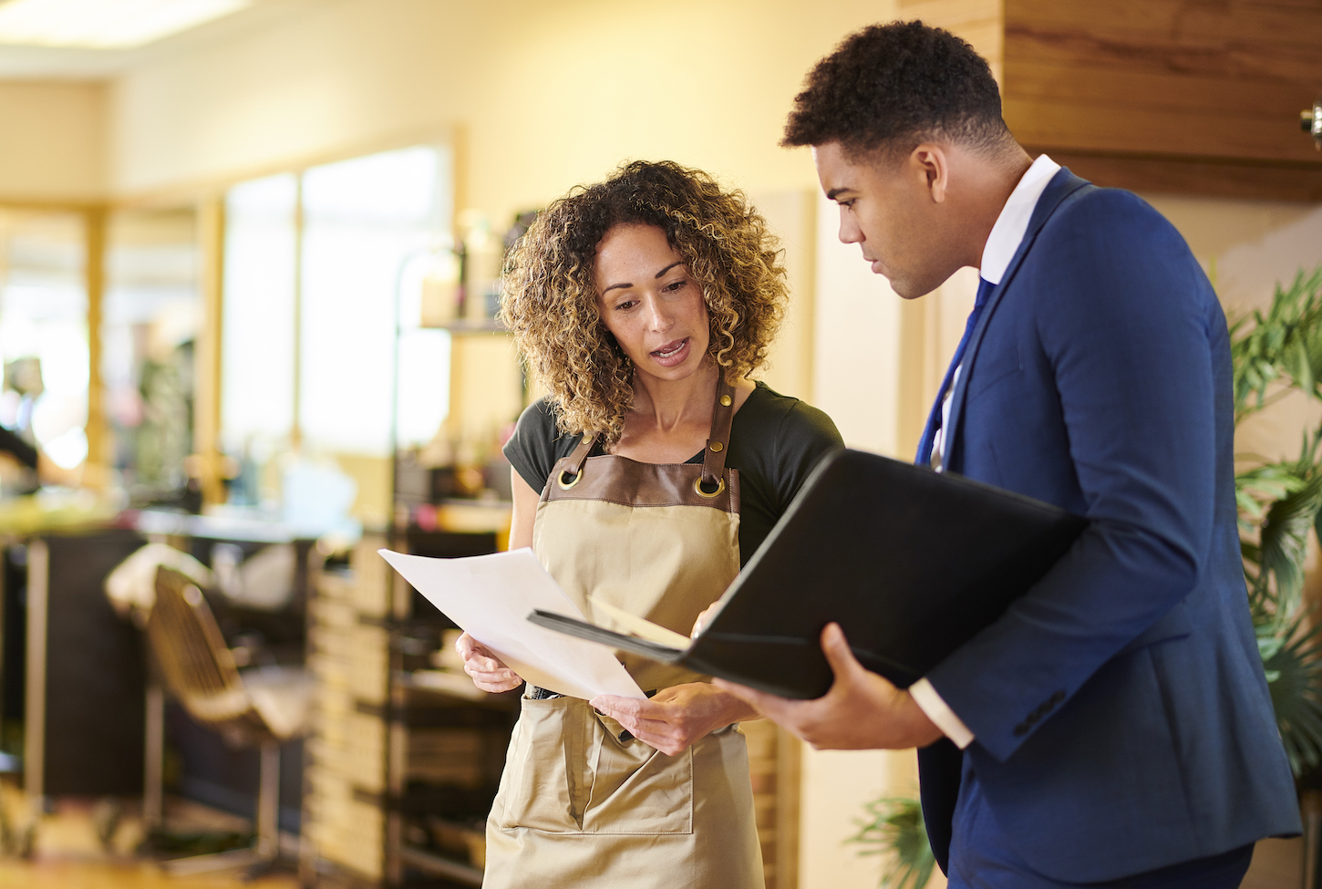 salon owner chatting to bank representative Small business owner in meeting